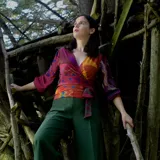 Blusa con estampado multicolor, con cuello en V, mangas 3/4 y corte cruzado con lazo en la cintura.