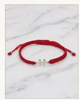 Pulsera de hilo rojo tejida en macramé con dije central de dos figuras de niños en plata 925 y terminaciones con esferas de plata. Diseño ajustable.