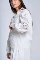 Camisa blanca de mangas largas con broderie y botones perlados.