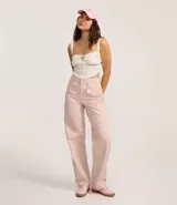 Pantalón femenino de sarga color rosa pálido, modelo baggy de cintura mediana, con trabillas, cierre tradicional y cinco bolsillos. Confeccionado con algodón certificado BCI.