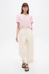 Pantalón jean slouchy de tiro alto, color natural, con detalle de bordadoado en el borde inferior.