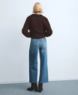 Jeans de corte wide leg con tiro medio, confeccionados en denim azul con acabado lavado y ruedo desflecado.