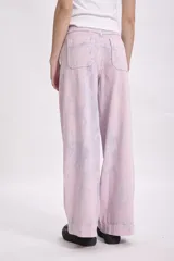 Pantalón de jean de corte ancho, color rosa con efecto tie-dye en lila. Tiro alto y bolsillos delanteros y traseros.