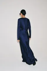 Vestido largo de satén color azul marino, de manga larga y escote redondo con pliegues en el pecho.