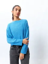 Sweater color crema de tejido de punto acanalado, corte cropped, cuello redondo y mangas largas.