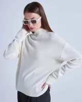 Sweater de lana color crema con cuello alto y mangas largas. Posee detalles calados en la parte superior del pecho y diseño acanalado en puños y ruedo.