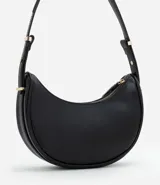 Bolso baguette en formato media luna, con correa de hombro ajustable mediante detalles metálicos y cierre superior por cremallera. Diseño minimalista con acabado liso.