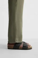 Sandalias marrones con doble tira ancha en el empeine, acabado engomado y ajuste con cierres adherentes. Plantilla anatómica y suela de corcho.