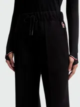 Pantalones deportivos Moncler de corte recto y tiro medio, confeccionados en tejido técnico negro. Presentan cintura elástica con cordón ajustable, costuras frontales marcadas y detalle de logo en el lateral.