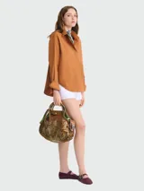 Bolso tipo shopper de red con diseño de malla, con solapa y asas de cuero marrón. Incluye un pañuelo estampado decorativo en uno de los laterales.
