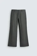 Pantalón de traje relaxed fit en color gris oscuro con diseño de espiga. Cuenta con bolsillos frontales, bolsillos traseros de vivo y cierre frontal con cremallera y botón.