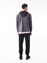 Campera deportiva con cierre frontal, capucha y diseño de bloques de color. La parte superior (hombros y capucha) es negra, y el cuerpo y mangas son de color azul vibrante, con un corte diagonal que separa ambos colores.