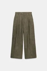 Pantalón de tiro medio con diseño de rayas verticales en tejido jacquard. Presenta pinzas en el delantero, cintura con trabillas, bolsillos laterales ocultos y cierre frontal con cremallera y botón.