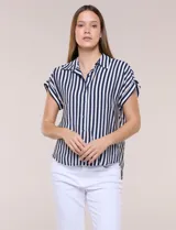 Camisa de calce holgado color blanco con rayas verticales negras, cuello camisero clásico, abotonadura frontal y mangas cortas.