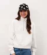 Gorra de sarga de algodón con visera curva, ojales bordados y estampado de lunares, con cierre posterior ajustable con hebilla metálica.