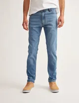 Pantalón de jean celeste, corte slim fit, con bolsillos delanteros y traseros.