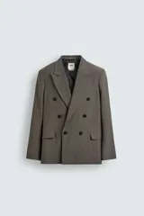 Blazer Zara de corte relajado confeccionada en mezcla de viscosa y lino. Presenta cuello con solapas de pico, cierre frontal de botonadura cruzada, bolsillos de solapa en la cadera y aberturas en la espalda.