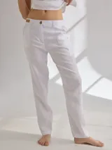 Pantalon de lino color blanco, de corte recto y tiro medio. Presenta costuras decorativas visibles, bolsillos laterales y cierre frontal con botón.