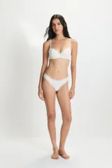 Conjunto de lencería compuesto por un corpiño con taza soft y aro, y una bombacha tipo vedetina. Ambas piezas presentan detalles de encaje en los bordes y están confeccionadas en un tejido suave y elástico.