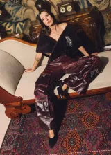 Pantalón cargo de cuero con efecto desgastado, de tiro medio y silueta recta amplia. Presenta múltiples bolsillos cargo con solapa y herrajes metálicos en el frente, además de bolsillos traseros de gran tamaño.