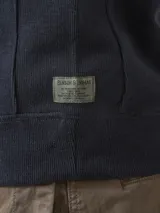 Buzo de frisa azul marino con cuello alto y cierre metálico azul.