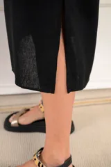 Túnica midi de color negro, con escote en V, mangas cortas y corte holgado. Confeccionada en una mezcla de viscosa y lino, ofrece una caída ligera y cómoda.