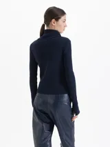 Cardigan de tejido de punto fino con silueta ajustada, cuello alto y cierre frontal de doble camino. Presenta mangas largas con aberturas para los pulgares.