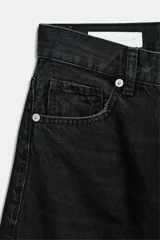 Jeans de mezclilla en color negro gastado, tiro alto, diseño de cinco bolsillos y corte de pierna ancha extra larga. Cuenta con cierre frontal de cremallera y botón metálico.