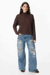 Sweater negro de punto trenzado con cuello alto.