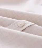 Camisa de manga larga confeccionada en tricolina de algodón, con cuello inglés, cierre frontal de botones y puños abotonados. Diseño liso y versátil.