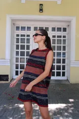 Vestido corto sin mangas, de tejido de punto en color azul marino con efecto jaspeado o tweed en tonos claros. Presenta un corte amplio y relajado, con cuello redondo y bordes en contraste.