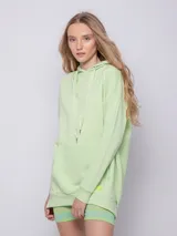 Canguro blanco oversize con capucha, cordones y bolsillo tipo canguro.