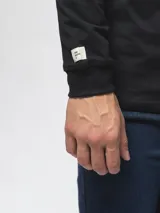 Remera de manga larga con cuello redondo, confeccionada en algodón, de corte clásico y diseño minimalista con detalle de etiqueta pequeña en el ruedo.