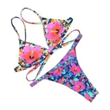 Top de bikini United Uy con diseño de estampado camuflado y flores grandes en tonos rosados, naranjas y celestes. Cuenta con copas triangulares, tirantes finos ajustables y tiras cruzadas en la parte inferior para atar en la espalda.
