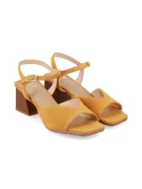 Sandalias de taco cuadrado y punta cuadrada de cuero gamuza mostaza, con escote en V en el empeine y tira ajustable con hebilla en el tobillo.