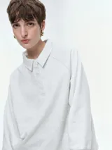 Buzo de cuello polo con escote abotonado, manga larga raglán y puños acanalados. Confeccionado en tejido suave y confortable.