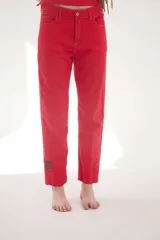 Pantalón de jean color rojo, de corte recto y tiro mid-rise, con pespuntes en contraste y parche de cuero en la parte inferior de la pierna.