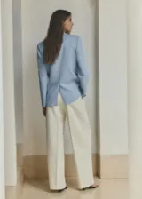 Blazer celeste de corte recto, con cuello de solapa con muesca, manga larga, bolsillos laterales con solapa y cierre frontal de un botón.