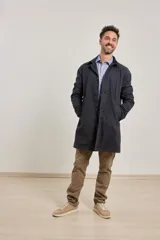 Gabardina color beige de algodón, con cuello clásico, cierre frontal con botones, dos bolsillos de ribete delanteros, bolsillo interior con botón y abertura posterior en el bajo.