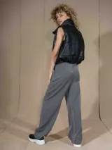 Pantalón de vestir ancho (wide leg) color gris oscuro, con cintura alta ajustable con lazo blanco y pliegues frontales.