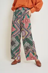 Pantalón italiano de seda con estampado geométrico en tonos verde, rosa, amarillo y negro. Tiene cintura elastizada y bolsillos laterales.