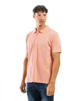 Remera polo de manga corta color salmón, confeccionada en algodón, con cuello clásico y tapeta de tres botones.