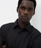 Camisa de microfibra de manga larga color negro, de calce regular, con cuello camisero y cierre frontal con botones. Incorpora tecnología Easy Care para un secado rápido y menor formación de arrugas.