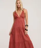 Vestido midi de corte evasé confeccionado en tejido laise de algodón. Presenta escote en V con busto fruncido, breteles finos torcidos con nudos y falda con recortes fruncidos y bordados calados.