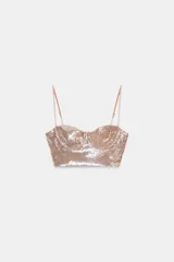 Top corto tipo bralette de escote corazón, cubierto completamente de lentejuelas color oro rosado. Posee tirantes finos ajustables.