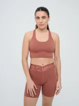 Top deportivo Umbro color marrón con diseño de espalda nadadora y banda elástica inferior.