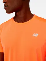 Remera deportiva New Balance modelo Accelerate SS de color naranja, de manga corta y cuello redondo, con pequeño logo reflectante en el pecho.