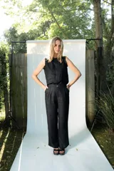 Pantalón de lino negro de corte sastrero, con pierna recta, pinzas en la parte delantera y tiro medio.