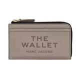 Billetera Marc Jacobs de cuero negro con cierre superior y tarjetero exterior. Presenta el texto "THE WALLET" grabado en relieve en la parte frontal junto con la marca "MARC JACOBS".