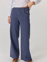 Pantalón de corte relajado color marrón oscuro, con costuras en hilo rojo a contraste y bordado decorativo en el bolsillo delantero.